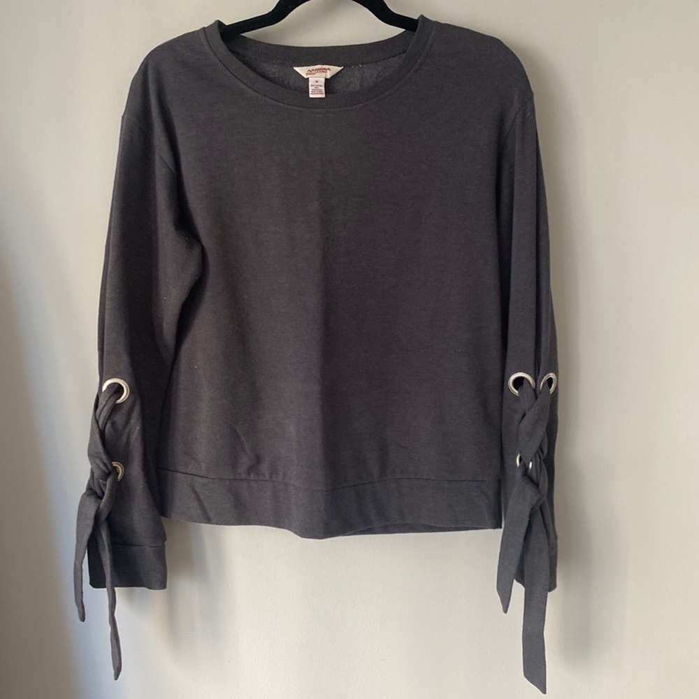 Grey pullover sweater with tie serial on sleeves.